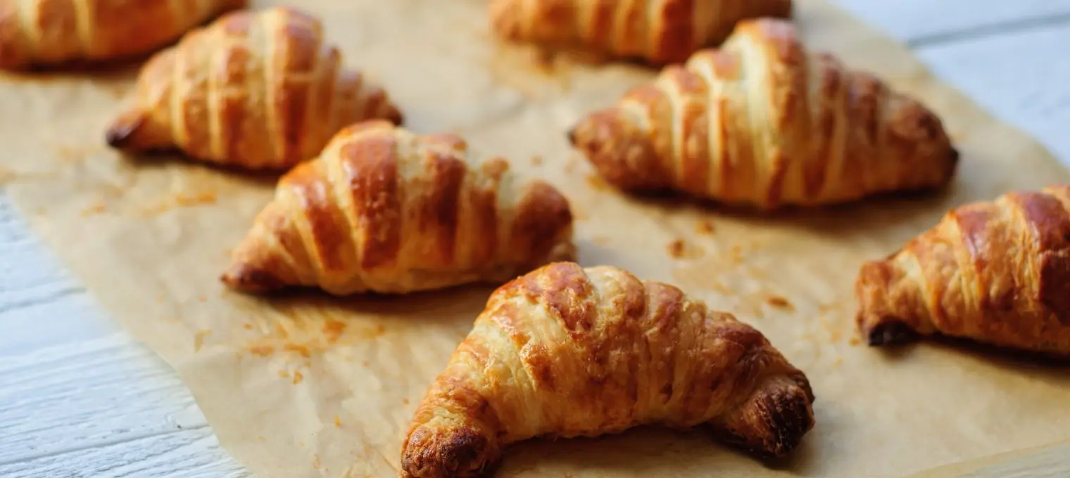 Frisch gebackene Croissants auf braunem Backtrennpapier Backtrennpapier online bestellen