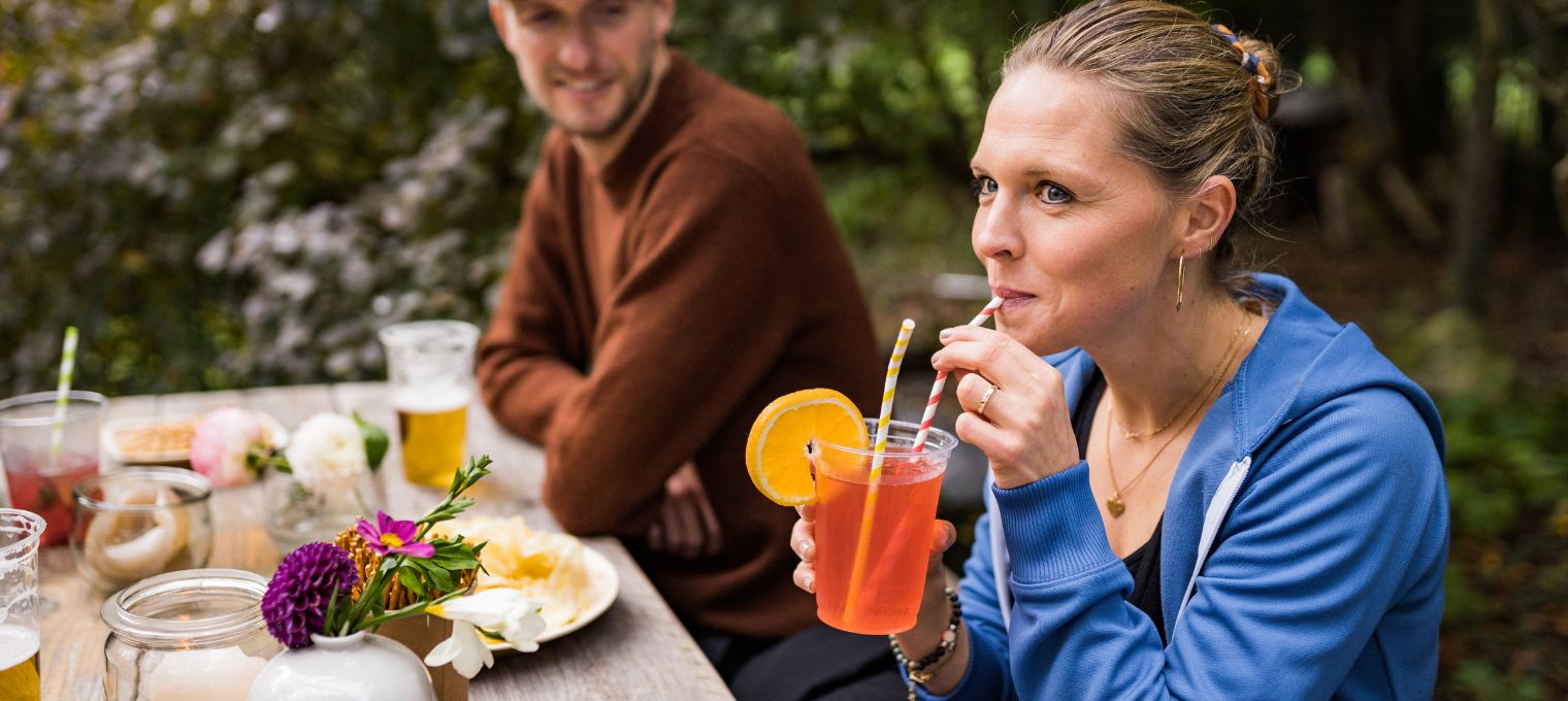 Plastikbecher mit Strohhalm und Orange garniert Plastikbecher für Cocktails und Softdrinks